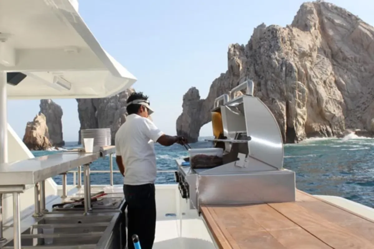 Chef at the grill on deck with the Arch behind