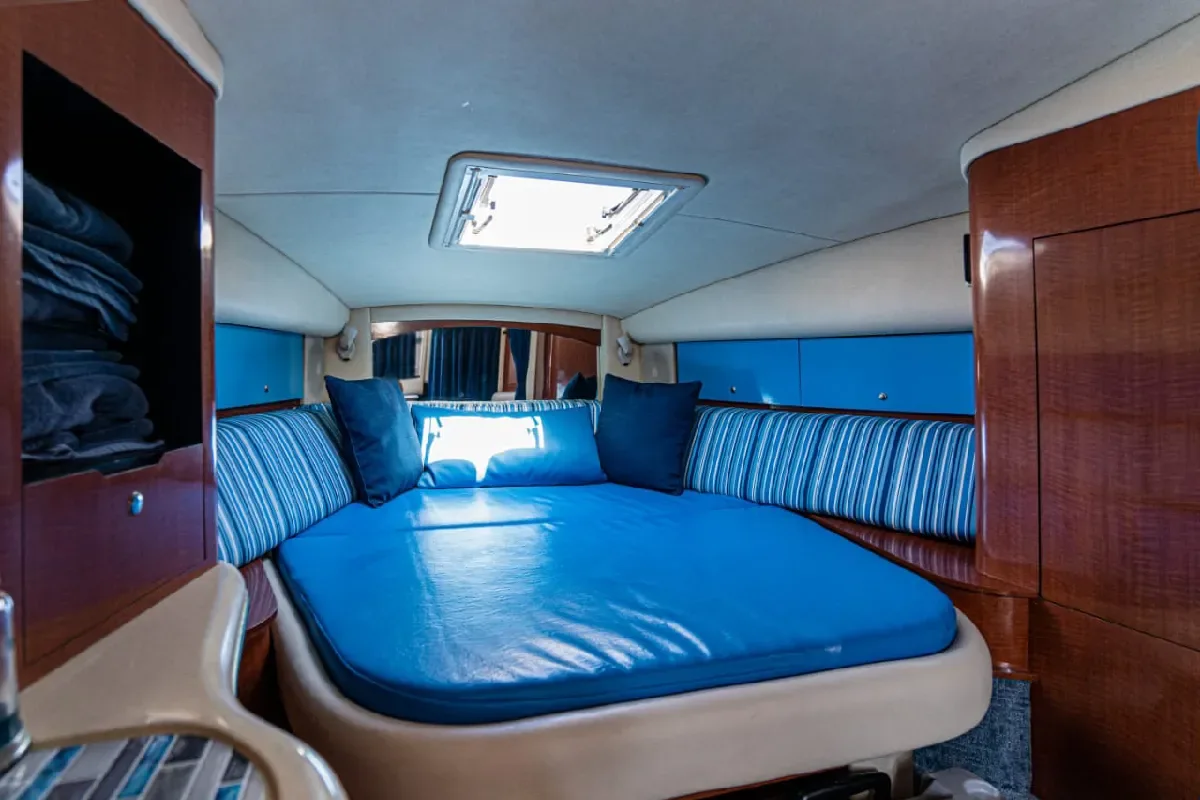 Cabin berth with blue upholstery on the 32' Sea Ray