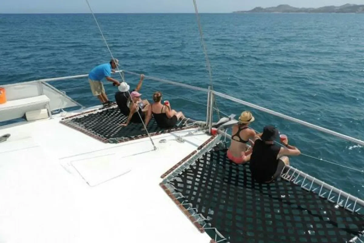 Guests relaxing on the bow netting at sea
