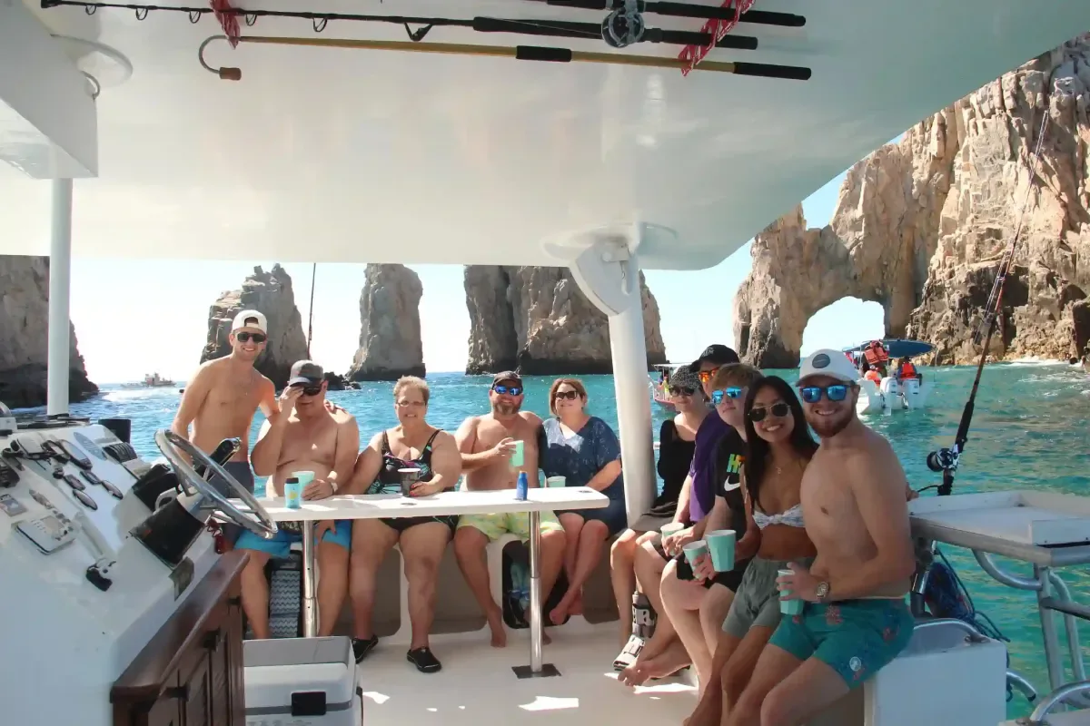 Guests at the shaded table with the Land's End rocks behind