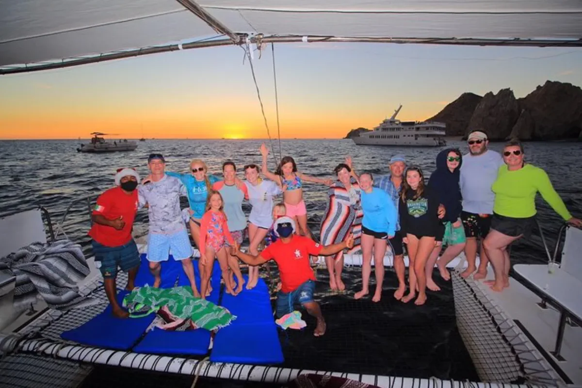 Group on the bow netting at sunset